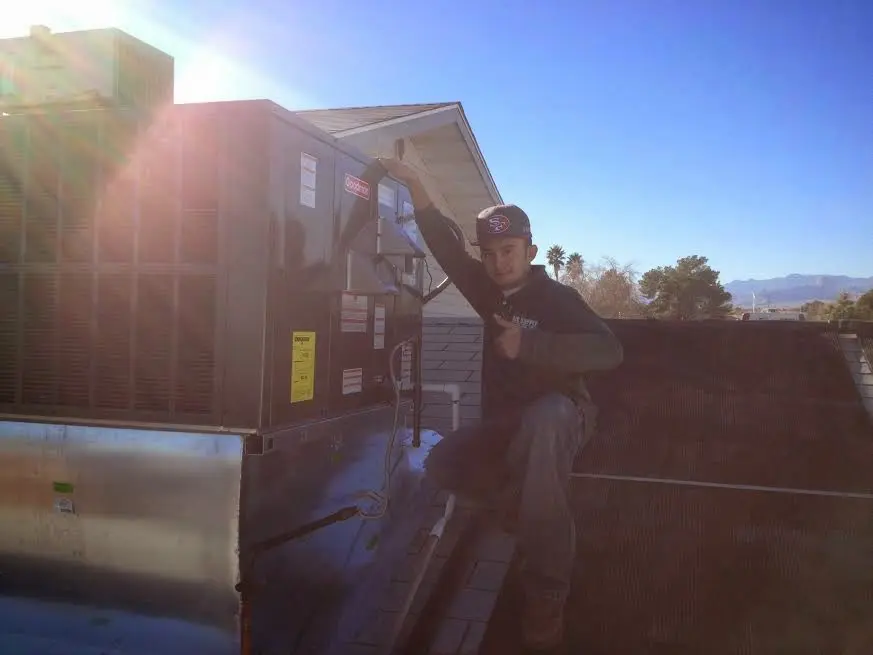 HVAC technician performing AC Tune-Up on a rooftop unit in Lexington Park